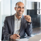 A businessman smiles while speaking with a client.